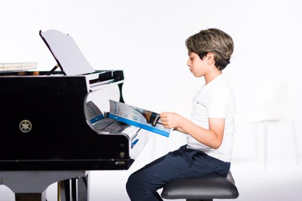 Redeem Code - Student with Book at Piano